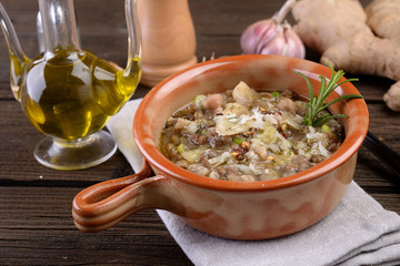Terracotta pot with soup of mixed vegetables and cereals