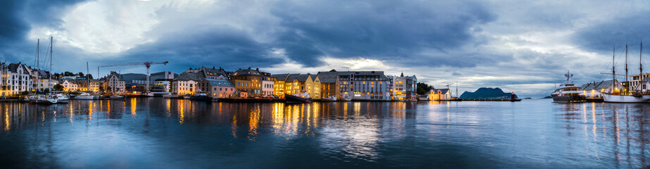 Sunset panorama of Alesund. Scenic view old city with reflection on water