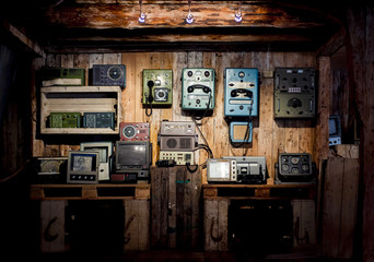 Retro devices on a wooden wall. Vintage measuring tools in a barn. Old phones.