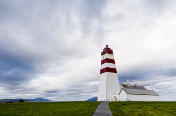 Fototapeta na wymiar Alnes lighthouse on island near Alesund in cloudy weather. Norway.