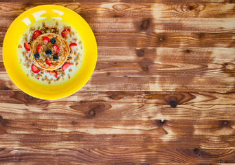 Homemade pancakes with fresh berries, strawberries, blueberries and maple syrup on a wooden background.