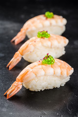 Three Sushi nigiri with shrimp on black background