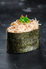 Gunkan maki sushi with crab meat and sauce spice on black background