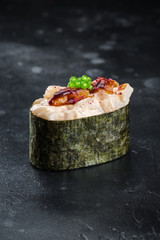 Three Gunkan maki sushi with scalop meat and sauce spice on black background