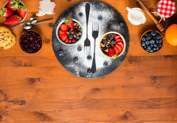 Cereal. Breakfast with muesli, and fresh fruits in bowls on a rustic wooden background,