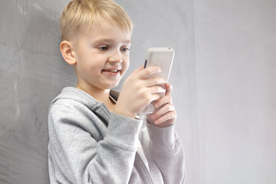 Zabawa na smartfonie.
Chłopiec gra na smartfonie w aplikację.
