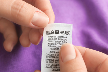 Woman reading instruction on clothing label, closeup