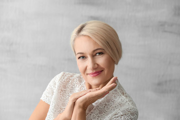 Fototapeta premium Portrait of beautiful mature woman on grey background