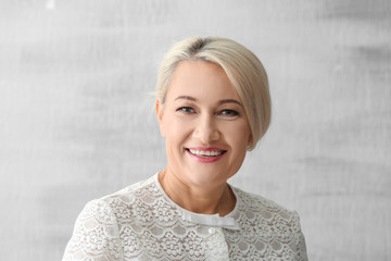 Obraz premium Portrait of beautiful mature woman on grey background