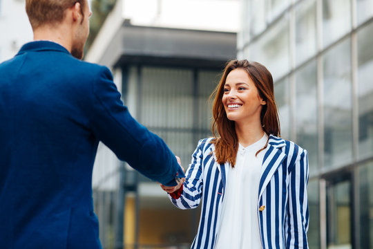 Businesswoman shaking hand to partner