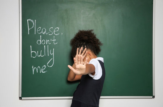 African-American Girl Near Chalkboard With Text 