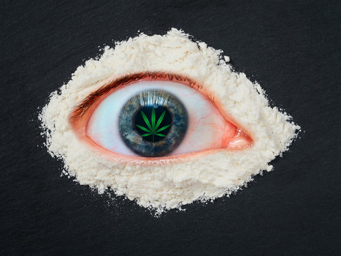 Drug abuse concept, overdose human eye with a leaf of marijuana in the pupil and heroin powder around