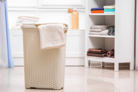 Plastic laundry basket with towel indoors