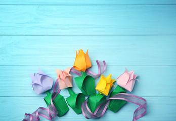 Colorful paper tulips on wooden background