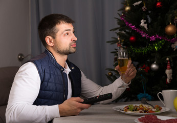 Man having christmas dinner  and watching tv at home