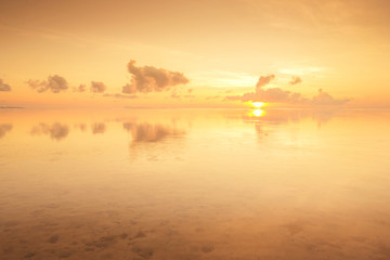 Fototapeta na wymiar golden sunrise with reflection on a calm sea water.