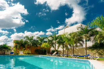 luxury tropical resort with swimming pool and green palm trees