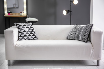 Comfortable sofa with pillows in room
