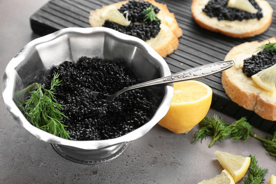Black caviar in metal bowl on table