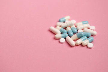 blue pills capsules on pink background closeup. place for text. 