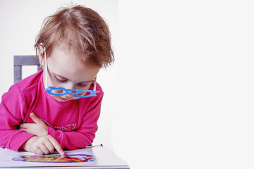 Naklejka premium beautiful little child girl learns to read (success, education, development concept)
