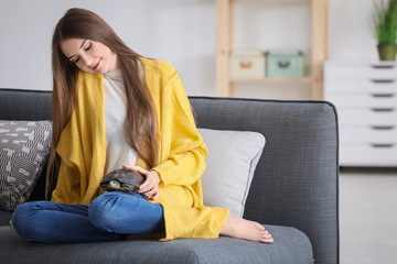Beautiful young woman with pet turtle at home