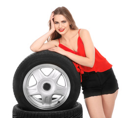 Fototapeta na wymiar Young woman in seductive outfit with car tires on white background