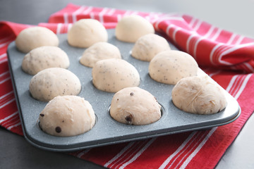 Raw dough in muffin tin on table