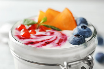 Yogurt with fruits in jar, closeup