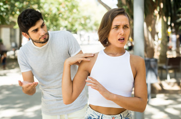 portrait of male and female talking emotional at the street