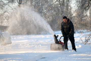 Fototapeta na wymiar Snow removal with a snow blower 
