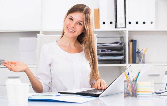 Female office worker making welcome gesture