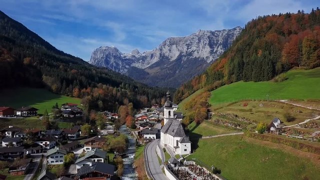 Flight over famous Parish church St. Sebastian, in Ramsau, Berchtesgaden, Bavarian Alps, Germany