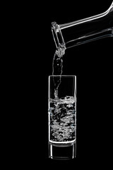 High shot is pouring vodka from a carafe.