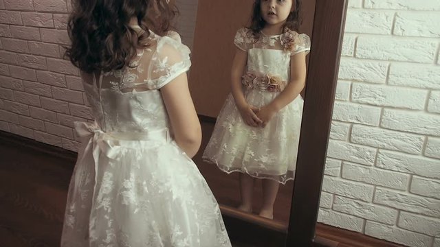 The child at the mirror. Beautiful little girl is looking in the mirror.