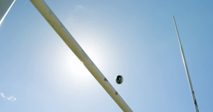 Rugby ball flying over golf post  