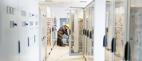 Two maintenance engineer work on relay protection system