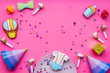 Baby shower. Cookies in shape of accesssories for child, party hats and confetti on pink background top view space for text