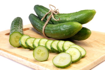 Cucumber and slices isolated over the wooden board 
