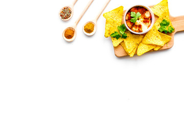 Middle Eastern cuisine. Bowl with hummus among pieces of crispbread and spices on white background top view copy space