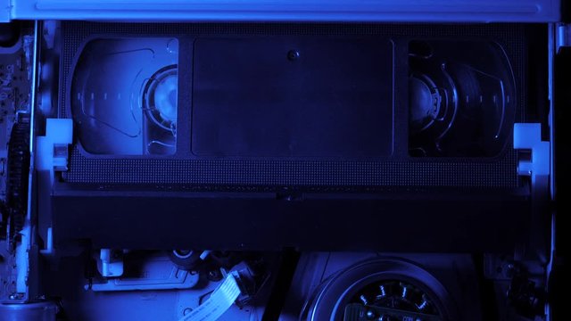 VCR VHS mechanics video cassette player insert tape magnetic head. Rotation reel with tape on the video, audio tape recorder or player. Closeup. Shallow depth of field. 4k