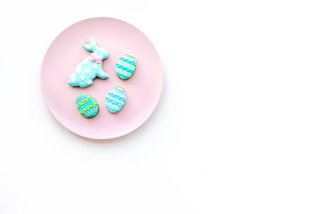 Easter background. Cookies in shape of easter bunny and easter eggs. White background top view space for text