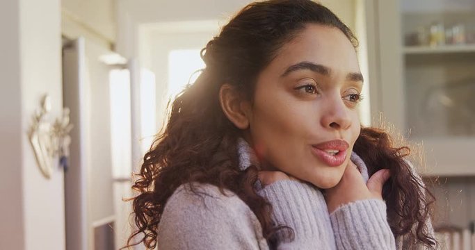 Woman wearing winter cloths standing in kitchen feeling cold  