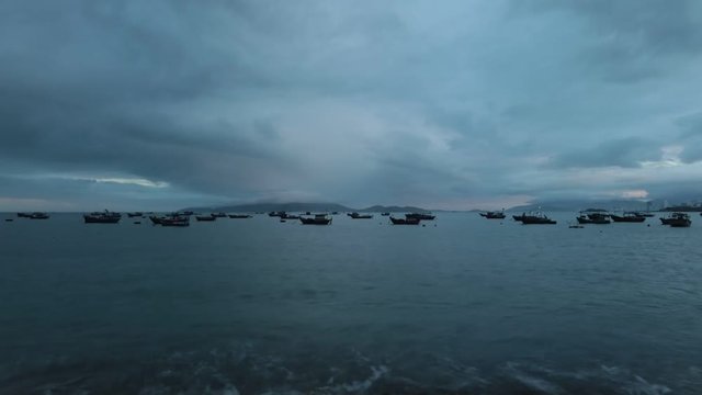 Vietnamese coastline looking out over the south china sea in Nha Trang Vietnam with a fleet of fishing boats high definition time lapse movie footage.