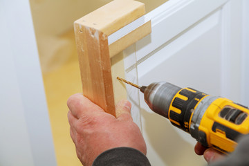 master drills the cabinet door in the cabinet door