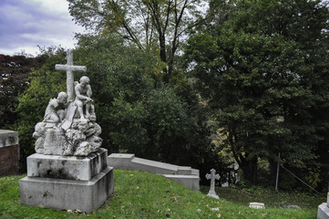 Statue of Two Angel Children with a Cross in a Cemetery