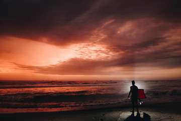 Obraz premium Persona en playa observando el atardecer