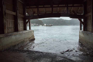 The boat house at Ine Boathouse is a traditional fishing village on a rainy day in Kyoto, Japan.