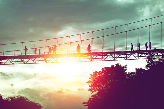 silhouette of tourist on suspension bridge walkway to the jungle in Surat Thani provine Thailand.