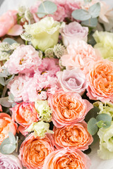 beautiful bouquet of mixed flowers in a vase on wooden table. the work of the florist at a flower shop